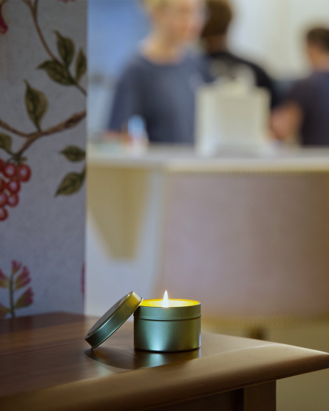 The candle lit at home, life happening around it